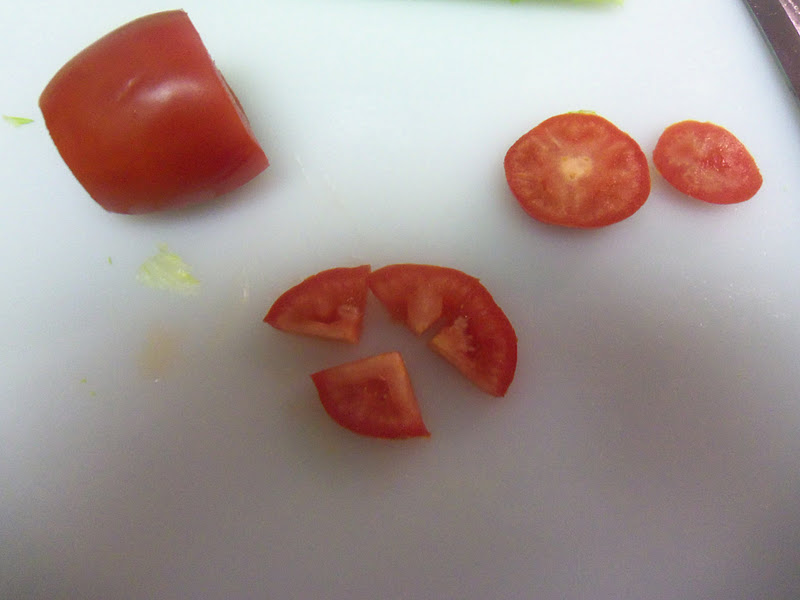 Cut the ends off the Roma tomato, slice it, and cut the slices into quarters