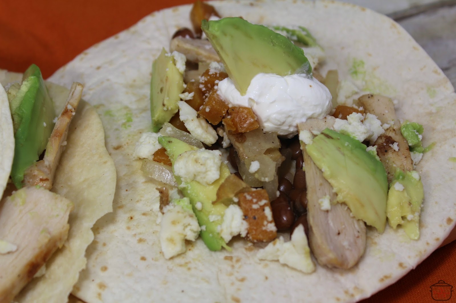 Slice the cooked chicken and layer it onto each tortilla with the butternut squash and shallots, pinto beans, avocado slices, and queso fresco