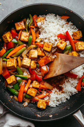 This image shows the cooked tofu and vegetables being served with optional toppings like sriracha or roasted peanuts.