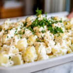 This image shows the finished potato salad being served, ready to be eaten at room temperature or after chilling.