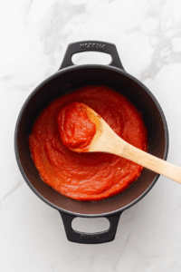 Stir in tomato paste, then add red wine and simmer for 5 minutes.