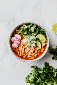 Quick & Comforting Chicken Pozole Recipe: Serve hot with garnishes like cabbage, radishes, cilantro, lime wedges, and Mexican cheese.