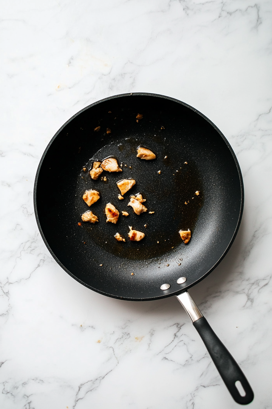 Heat half the vegetable oil in a large skillet or wok over medium-high heat. Add chicken pieces and cook until no longer pink, about 5-6 minutes. Remove and set aside.