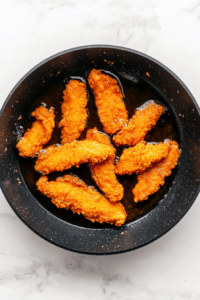 Fry chicken strips until golden and crispy, about 3–4 minutes per side.