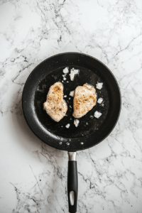 Heat olive oil in a skillet over medium heat and fry chicken until golden brown on both sides, about 3-4 minutes per side.