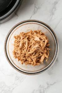 Remove chicken, shred the meat, and set aside. Strain the broth.