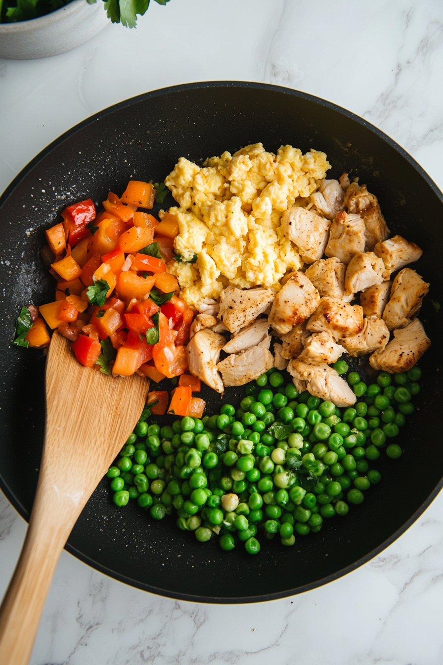 Add cooked brown rice, frozen peas, and cooked chicken back into the skillet. Stir to combine.