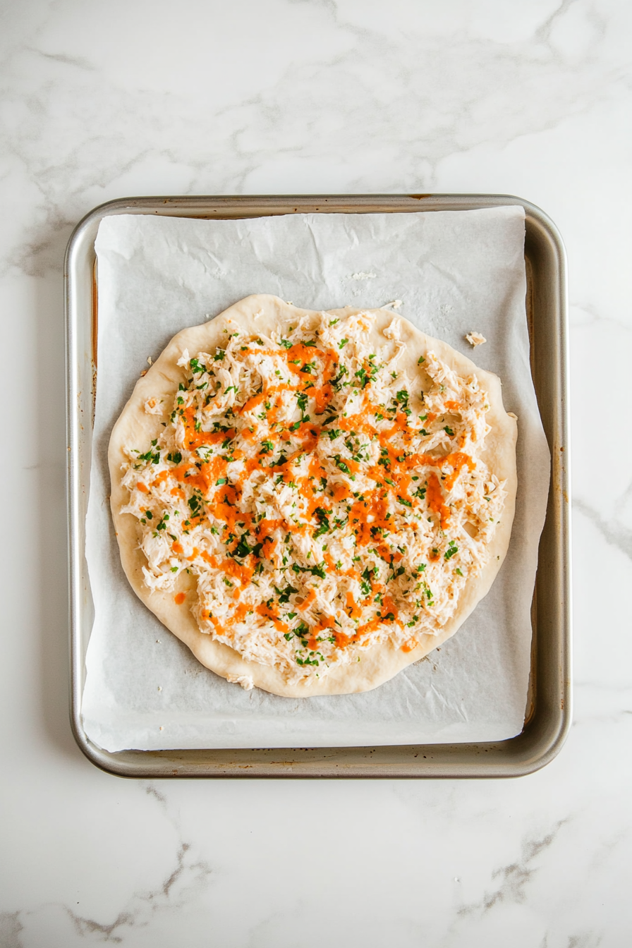 Spread the mixture into a round pizza shape on the tray.