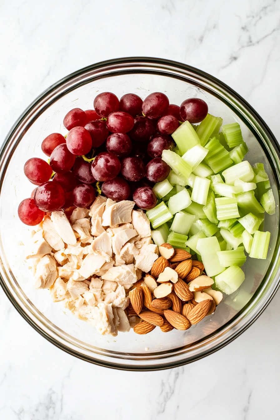 Add diced chicken, celery, grapes, and toasted almonds to the bowl.