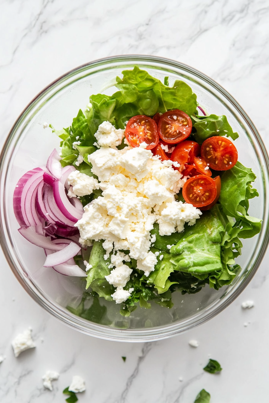 Crumble feta cheese over the salad mix.