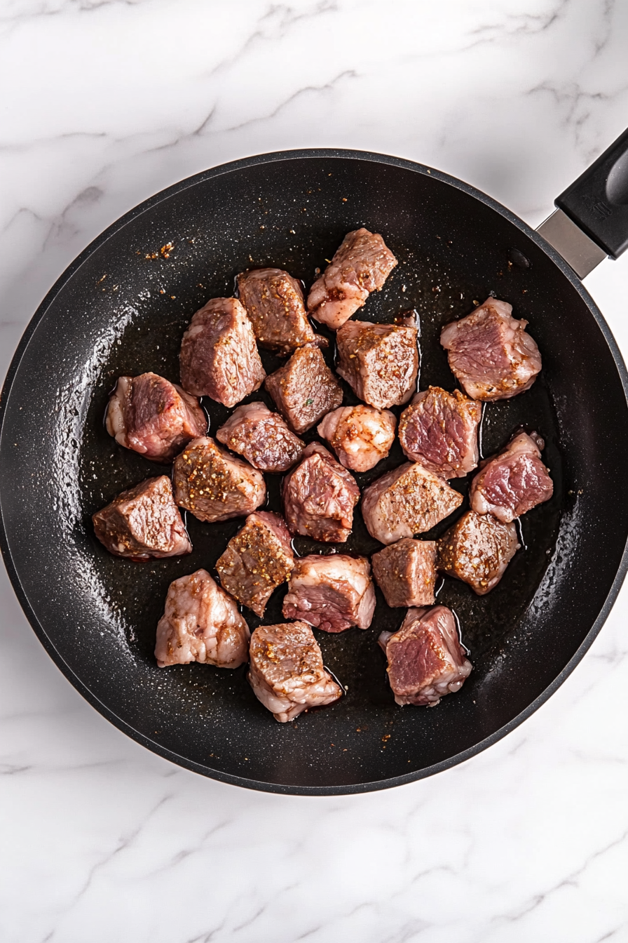 Add lamb chunks and brown on all sides, stirring frequently.