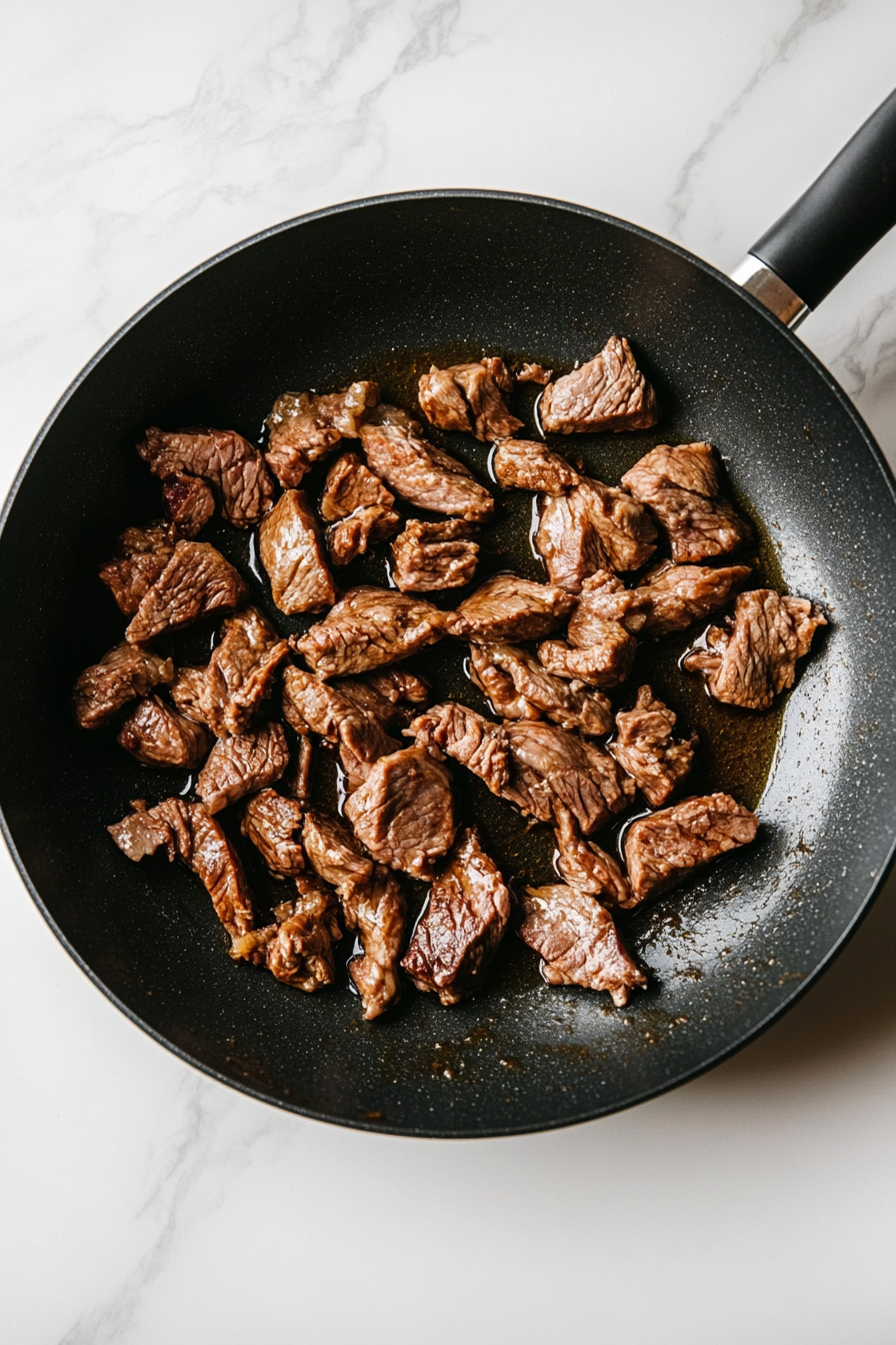 Heat vegetable oil in a pan and cook lamb until crisp on the edges.