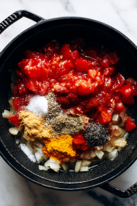 Add tomatoes, salt, cumin, chili powder, black pepper, turmeric, and cook until oil separates.