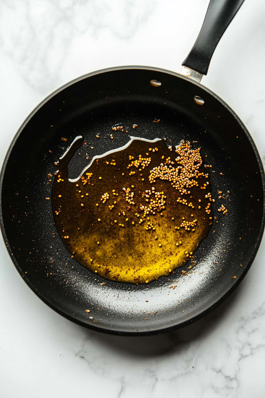 Heat oil in a large skillet over medium heat. Add cumin seeds and let them sizzle.