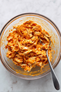 In a bowl, mix shredded chicken, buffalo sauce, and garlic powder.