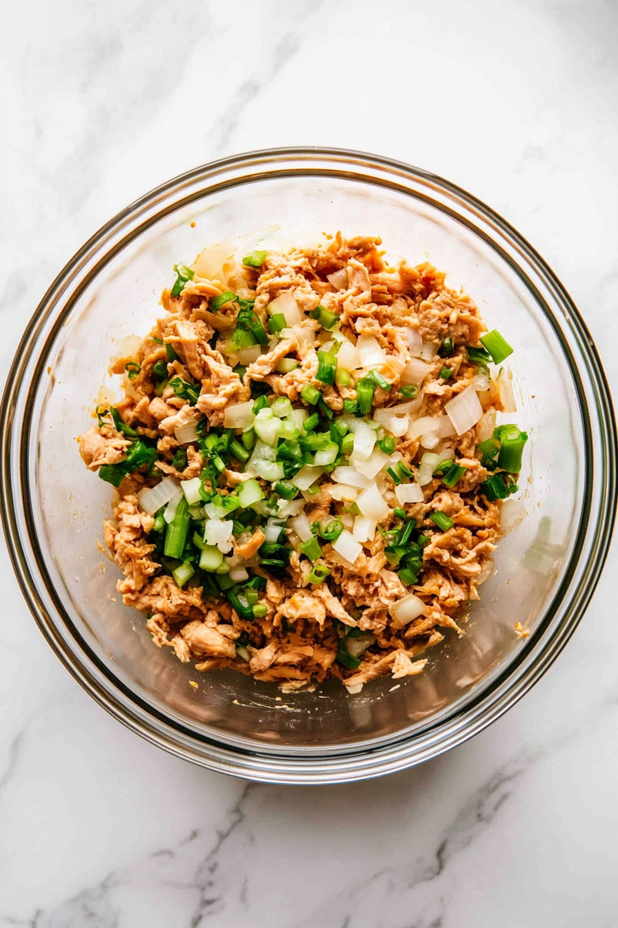Mix chicken mince with chopped onion, celery, spring onion, ginger, garlic, oyster sauce, cornflour, salt, and pepper.