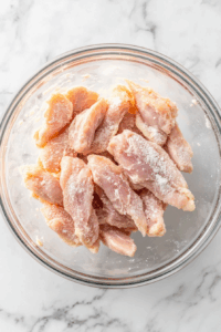 Prep the chicken: Cut chicken breast tenderloins into thin strips and toss with cornstarch until lightly coated.