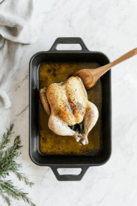 Rub olive oil over the chicken and place it breast side up in the roasting pan.