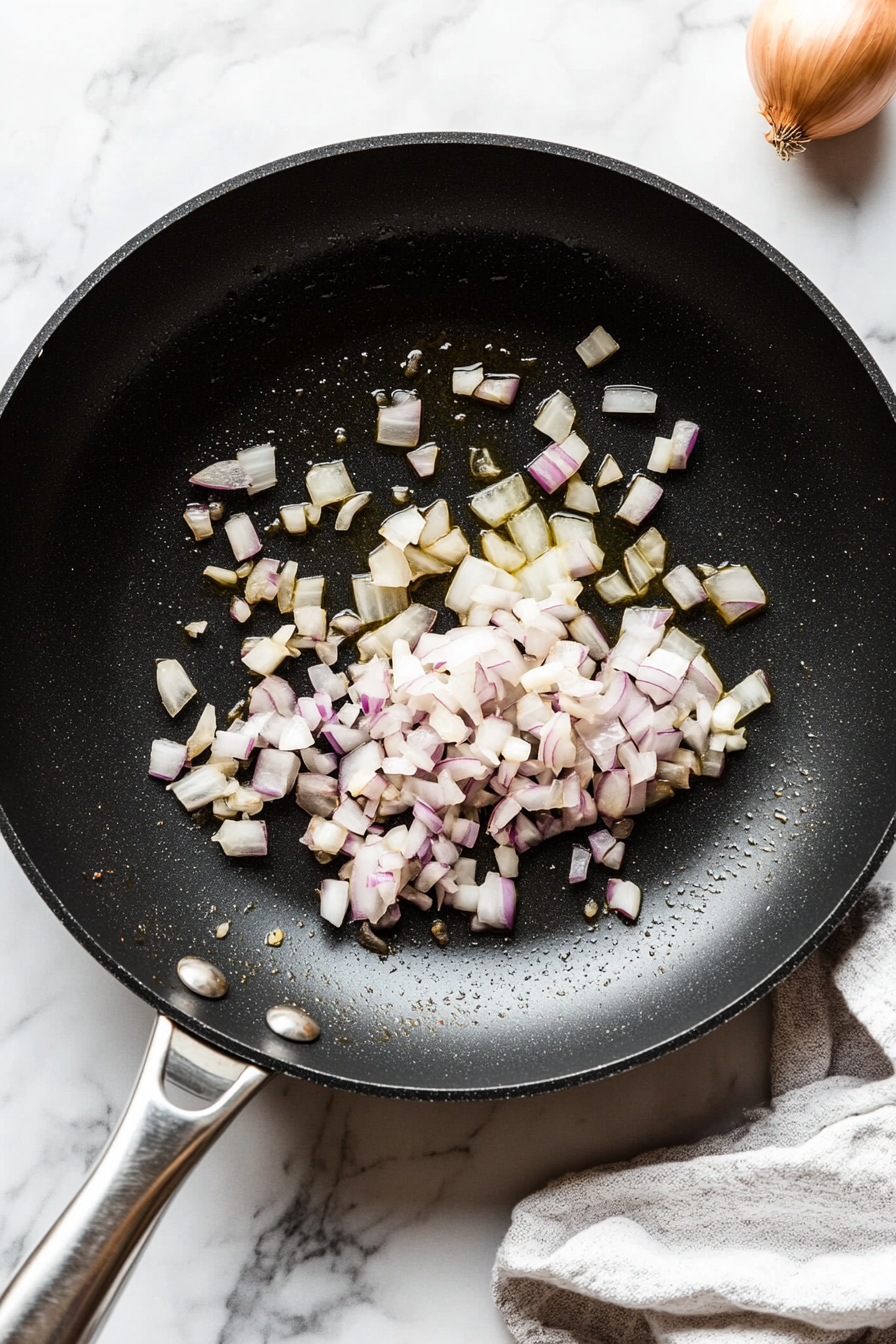 In the same pan, sauté garlic and chopped red onion until fragrant and soft.