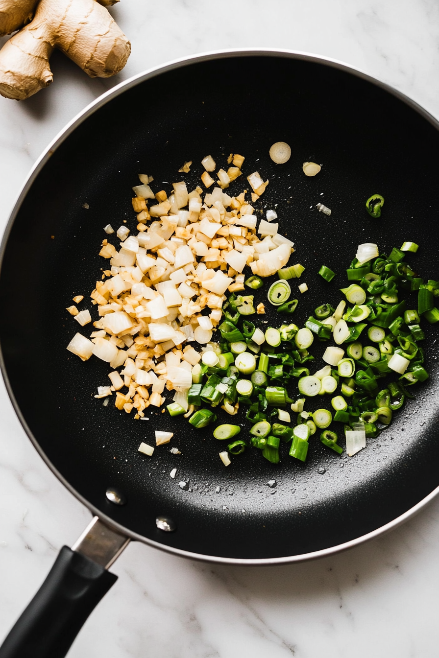 Remove the chicken and set aside. In the same pan, sauté garlic, ginger, and scallions until fragrant.