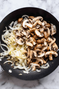 Sauté onions until soft, then add mushrooms and cook until browned.