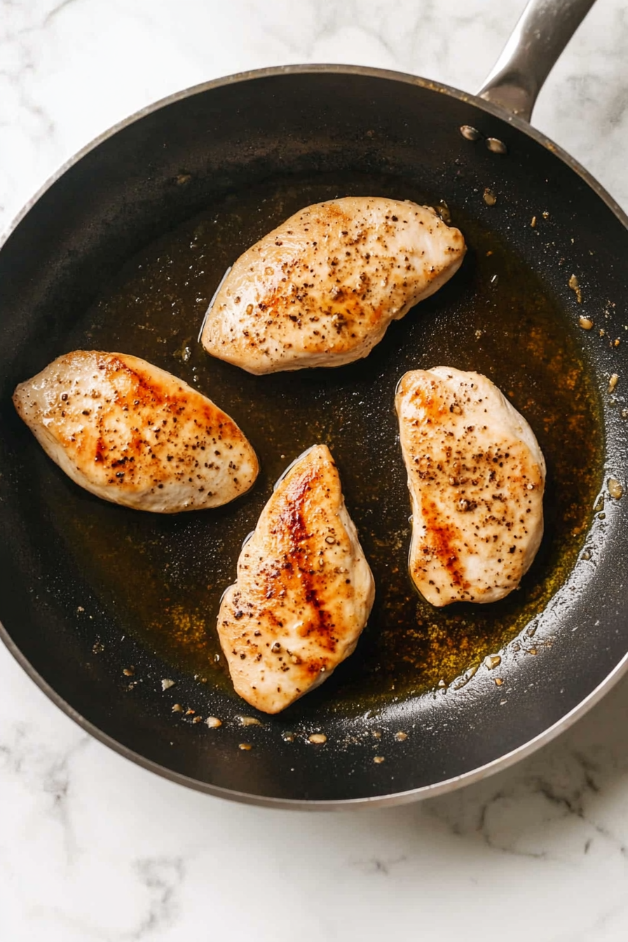 Heat olive oil in a skillet over medium heat and sear chicken until golden, about 3-4 minutes per side. Remove and set aside.