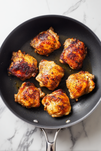 Heat oil in a large skillet and sear chicken on both sides until browned. Remove and set aside.