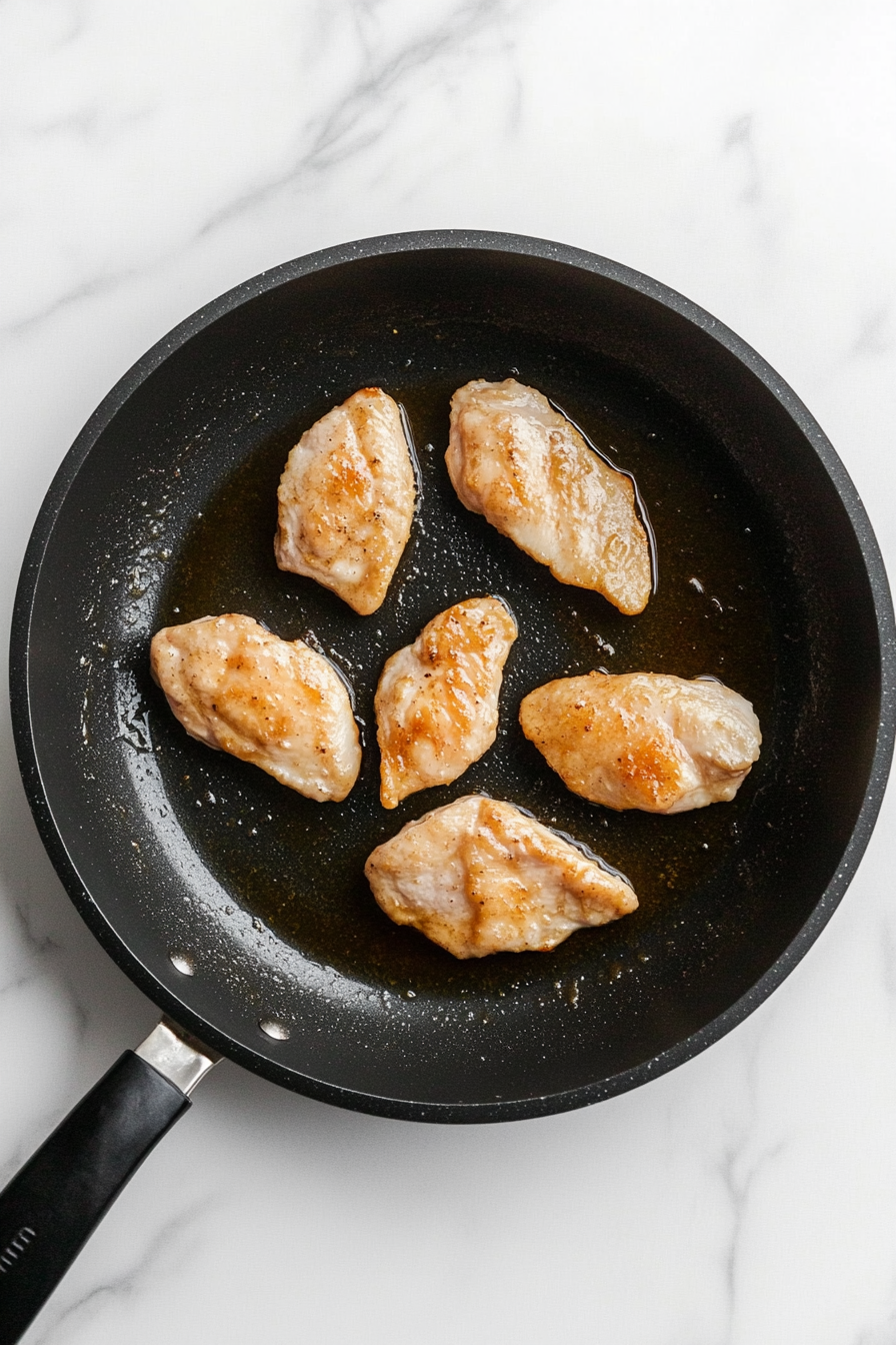 Heat oil in a skillet over medium-high heat, then sear the chicken until golden and cooked through.