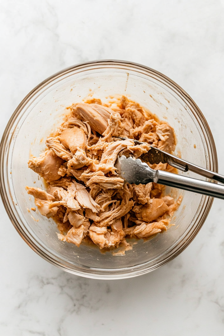 Remove chicken, shred the meat, and discard bones and skin.
