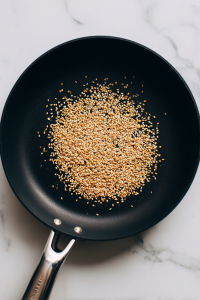In a pan, toast sesame seeds until golden, then set aside.