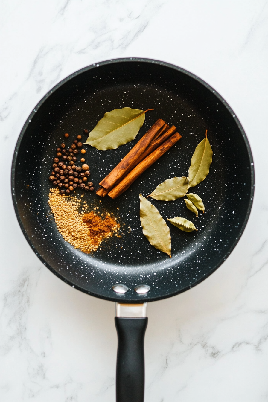 Heat ghee or oil in a large pan over medium heat. Add cumin seeds, cinnamon stick, cardamom pods, and bay leaves; sauté until fragrant.