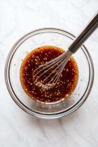 In a bowl, whisk together sweet chili sauce, soy sauce, brown sugar, sriracha, rice vinegar, fish sauce, garlic, lemongrass paste, lime juice, and sesame oil to make the glaze.