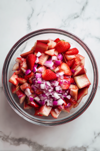 In a mixing bowl, combine rhubarb, strawberries, and red onion.