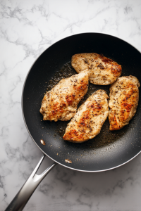 Heat olive oil in a skillet and cook chicken until golden and cooked through. Slice thinly.