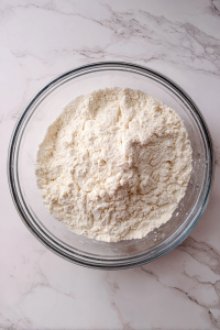 Mix flour, salt, baking soda, and oil; gradually add water to form a stiff dough. Rest it for 20 minutes.