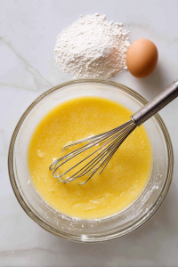 While crust bakes, whisk together eggs, sugar, flour, and salt in a large bowl.