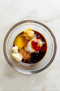 In a bowl, whisk together sesame oil, soy sauce, rice vinegar, honey, garlic, ginger, and chili oil.