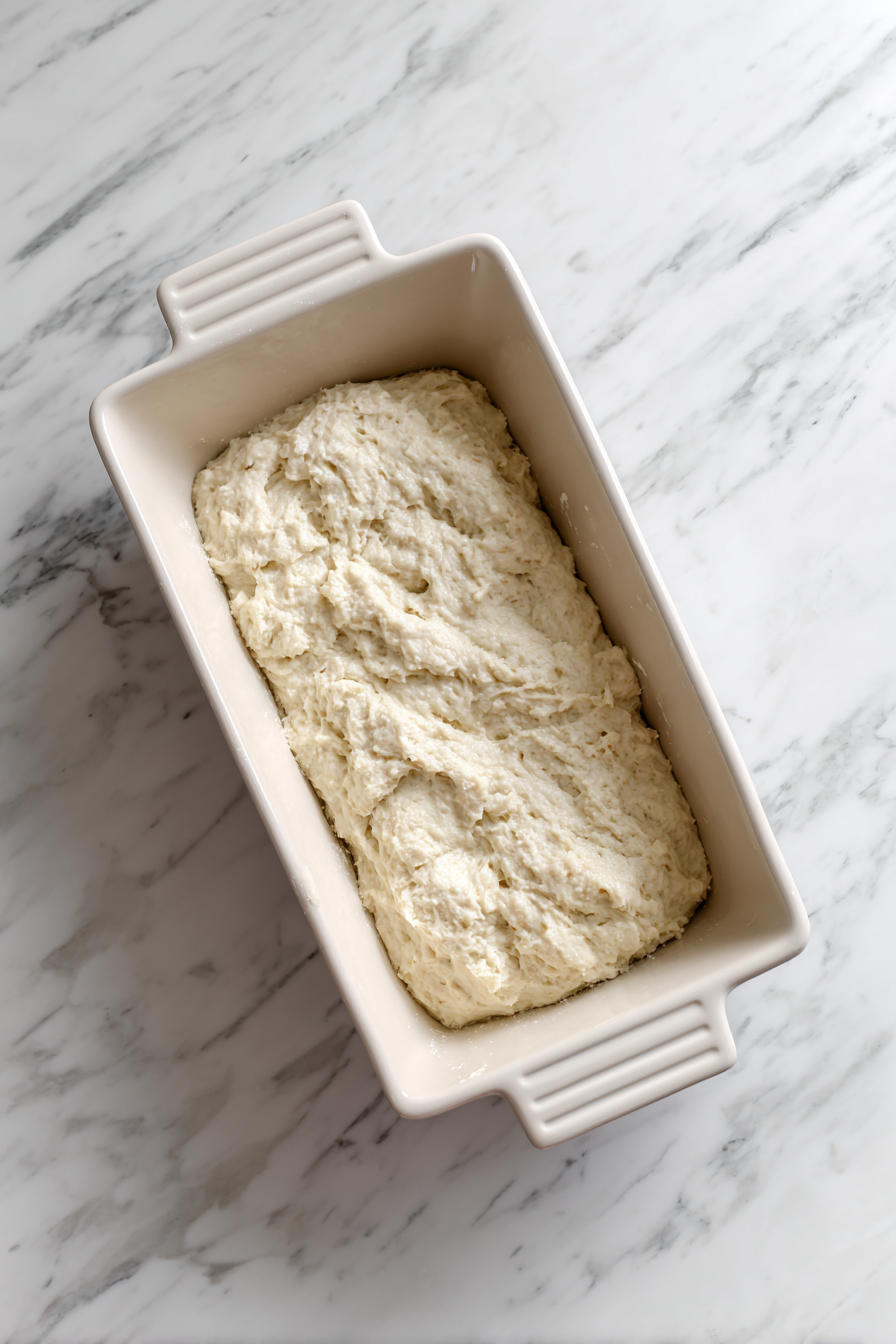 Pour the batter into the prepared loaf pan and smooth the top.