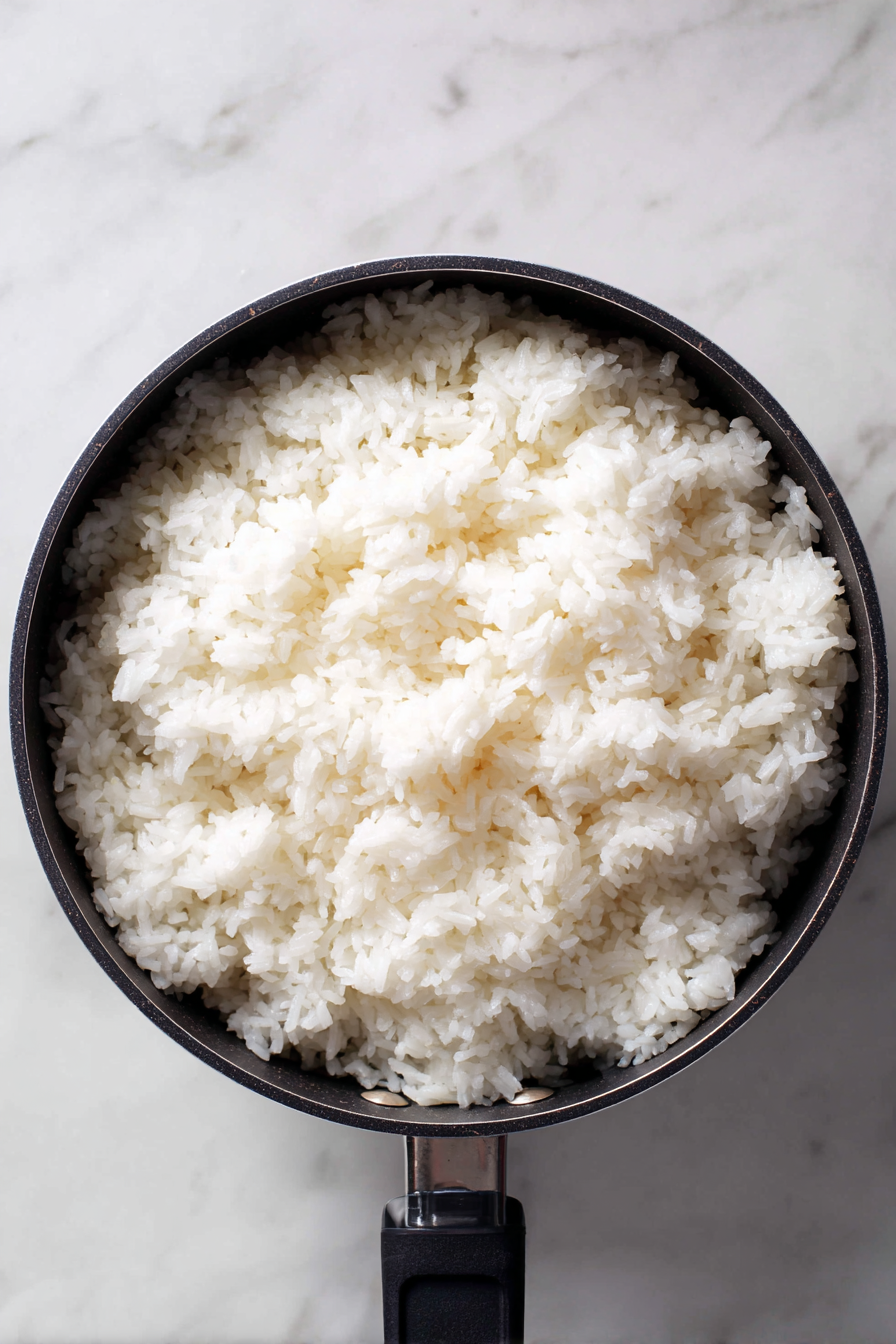 Once cooked, stir in rice vinegar, sugar, and salt. Let cool slightly.