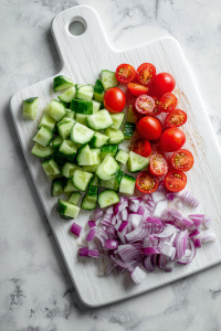 Peel (optional) and finely chop cucumbers, tomatoes, and onions.
